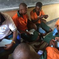 Doreen guiding learners to ensure they produce quality knitted reusable sanitary pads